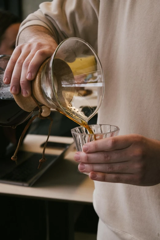 a person pouring a drink into a glass, pexels contest winner, celebration of coffee products, crisp detail, manuka, straining