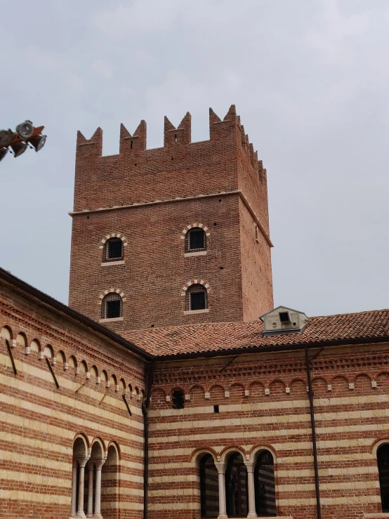 a large brick building with a clock tower, inspired by Taddeo Gaddi, castles floating in mid air, photo from behind, hiding in the rooftops, photo taken in 2018