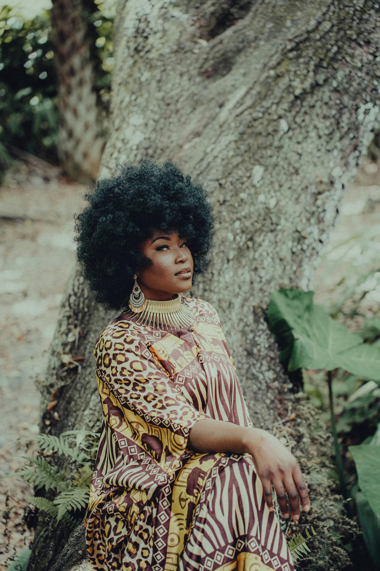 a woman sitting on the ground next to a tree, an album cover, pexels contest winner, afrofuturism, plus size, big hair, wakanda, looking this way