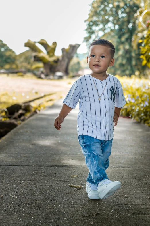 a little boy that is walking down a sidewalk, inspired by Master of the Bambino Vispo, pexels contest winner, modeling shoot, joel torres, jeans and t shirt, super detailed