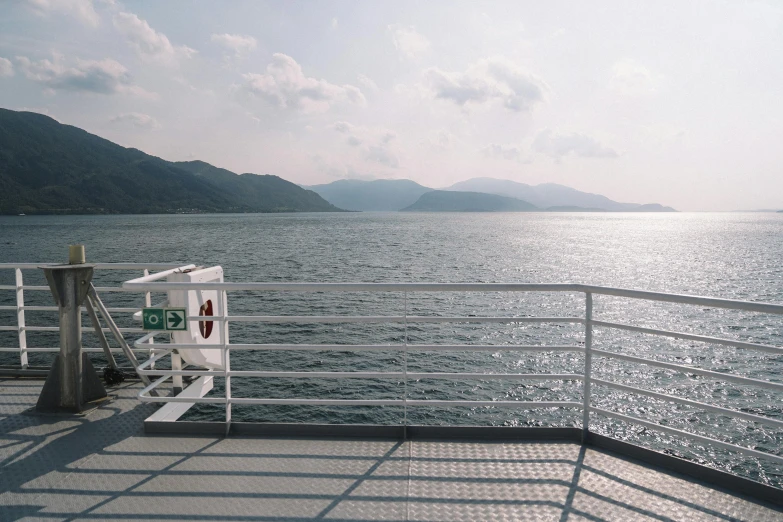 a large body of water with mountains in the background, by Carey Morris, pexels contest winner, romanticism, on the deck of a ship, tomoyuki yamasaki, crisp smooth lines, checkerboard horizon