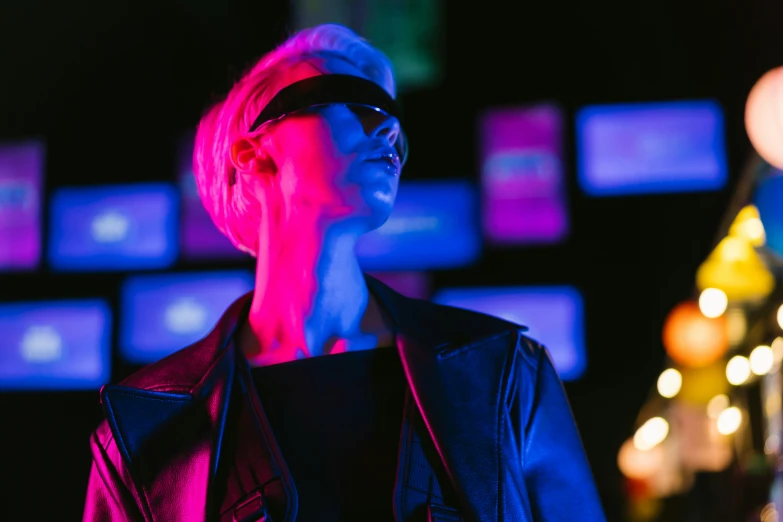 a woman standing in front of a wall of neon lights, cyberpunk art, inspired by roger deakins, trending on pexels, digital sunglasses, annie leonhart in a neon city, film still of emma watson, sleek oled blue visor for eyes