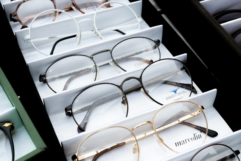 a drawer full of glasses sitting on top of a table, rounded eyeglasses, pyromallis rene maritte, medium frame, ecommerce photograph