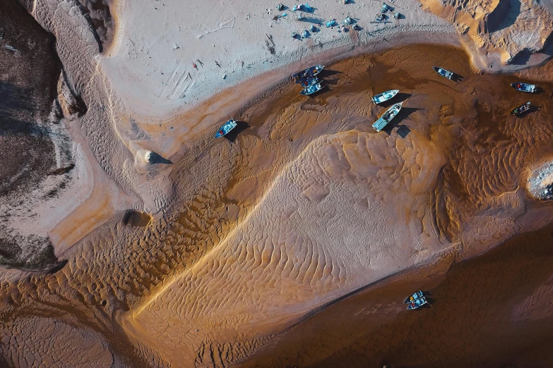 a group of boats sitting on top of a sandy beach, by Daniel Lieske, pexels contest winner, hurufiyya, desert of distortion, thumbnail, tiny details, off-roading