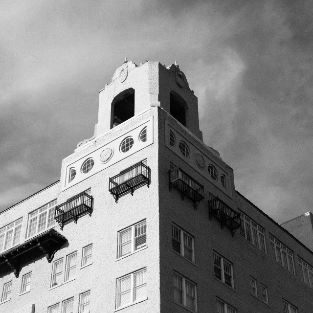 a black and white photo of a tall building, a black and white photo, art deco, in savannah, pueblo architecture, dramatic”, overlooking