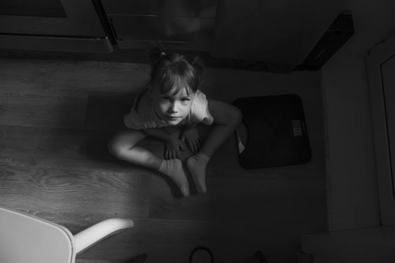 a black and white photo of a little girl sitting on the floor, by Emma Andijewska, pexels, terrifying, girl standing, 15081959 21121991 01012000 4k, in suitcase