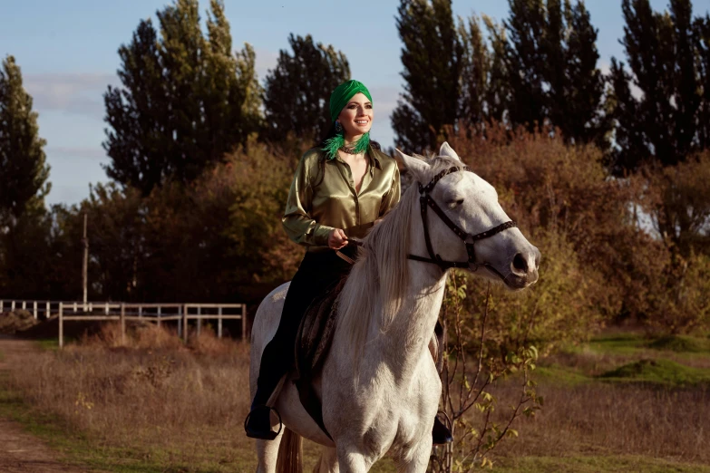 a woman riding on the back of a white horse, by Emma Andijewska, green clothes, ukraine. professional photo, turban, high quality upload