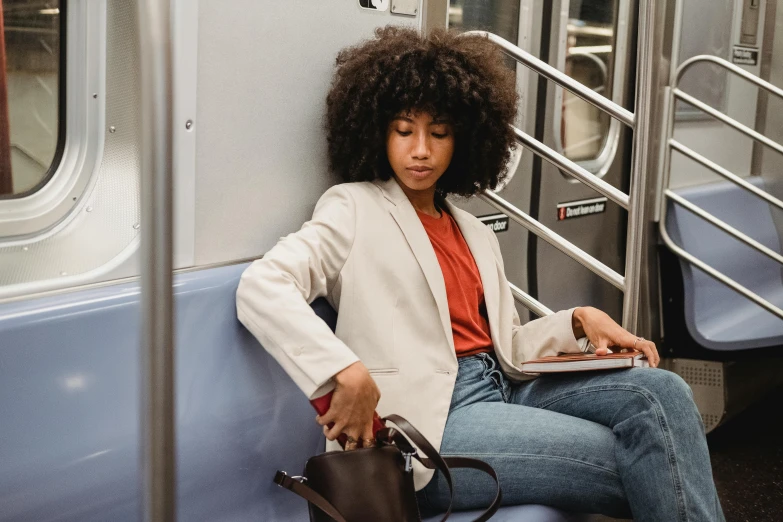 a woman sitting on a subway holding a laptop, trending on pexels, tailored clothing, essence, rebecca sugar, wearing a blazer