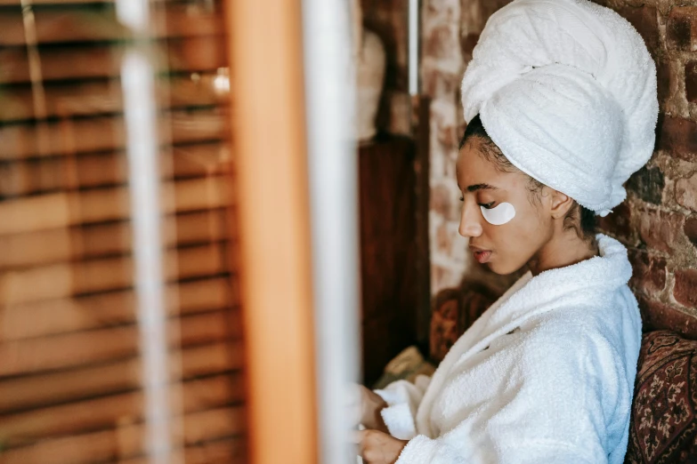 a woman with a towel wrapped around her head, trending on pexels, renaissance, manuka, luxurious environment, left eye stripe, with brown skin