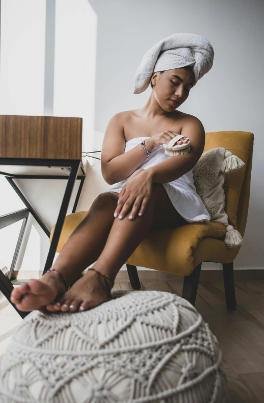 a woman sitting in a chair with a towel on her head, by Robbie Trevino, pexels, olive thigh skin, latina skin, te pae, gif