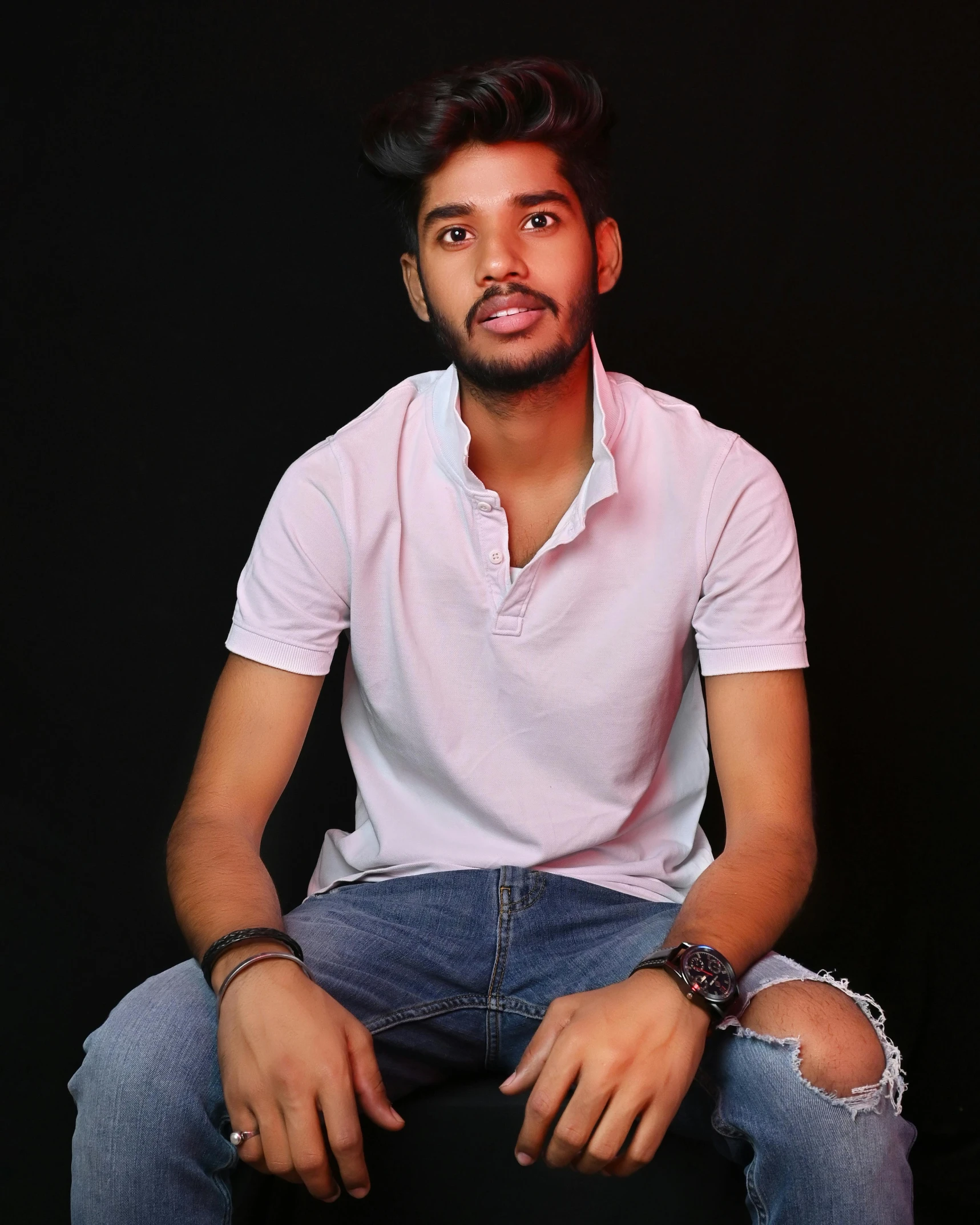 a man sitting on a chair in front of a black background, jayison devadas, wearing pants and a t-shirt, lgbt, ( ( ( wearing jeans ) ) )