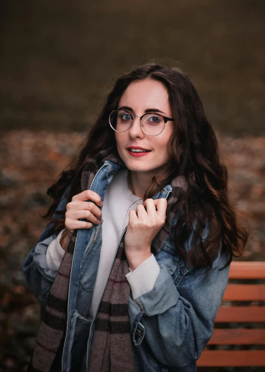 a woman sitting on top of a wooden bench, by Carey Morris, pexels contest winner, photorealism, square rimmed glasses, cute young woman, wearing jacket, amouranth