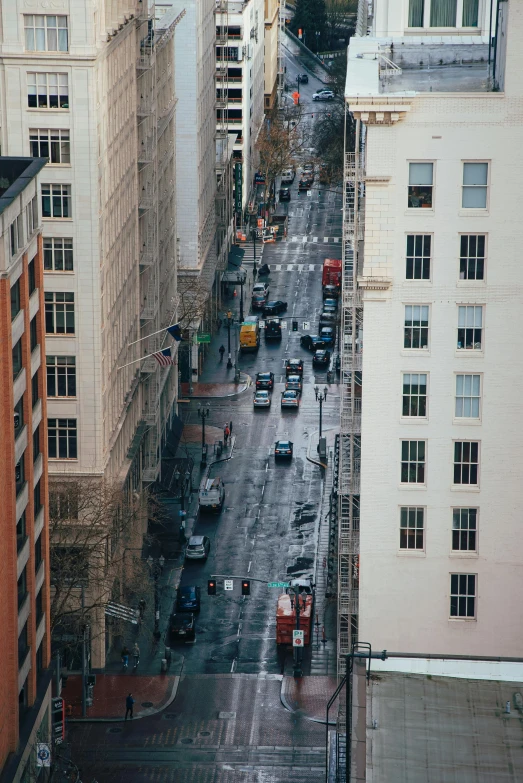 a city street filled with lots of tall buildings, a tilt shift photo, unsplash contest winner, oklahoma, wet streets, square, spanish