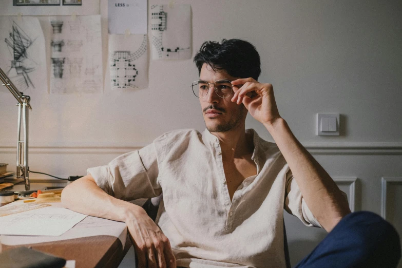 a man sitting at a desk in front of a computer, by Emma Andijewska, pexels contest winner, serial art, two models in the frame, wearing square glasses, thinking pose, ross tan