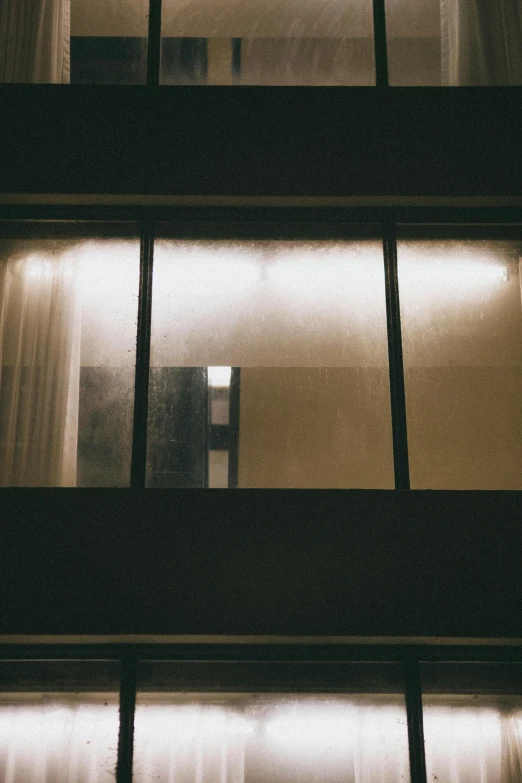 a view of the outside of a building at night, inspired by Elsa Bleda, unsplash, postminimalism, window in room, condensation, lonely and sad, instagram photo