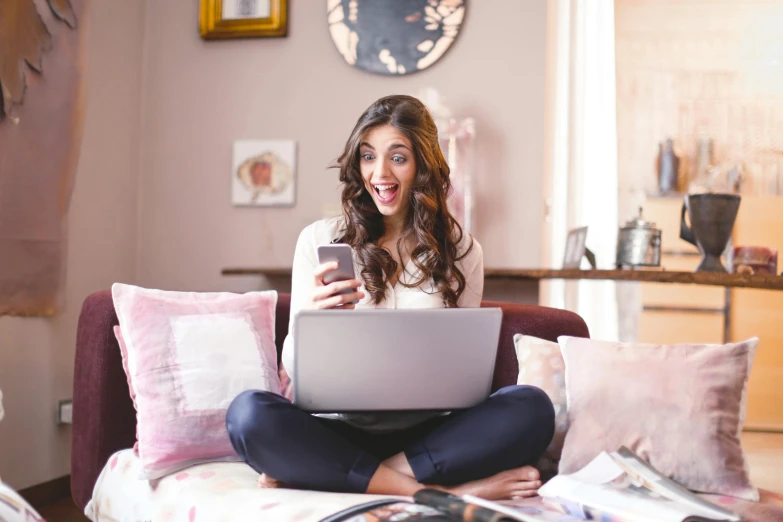 a woman sitting on a couch using a laptop computer, a picture, trending on pexels, happening, mutahar laughing, sitting on the bed, maya ali, avatar image