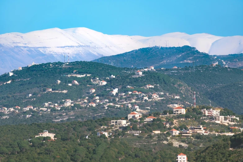 a view of a town with a mountain in the background, pexels, dau-al-set, with snow on its peak, greek ameera al taweel, 🌲🌌, 2000s photo