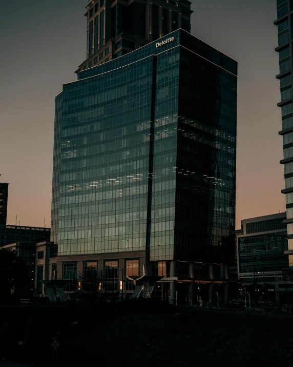 a couple of tall buildings sitting next to each other, unsplash contest winner, early evening, full of clear glass facades, low quality photo, dimly lit