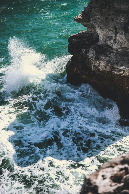 a man standing on top of a cliff next to a body of water, rough waves, limestone, instagram photo, vivid contrasts