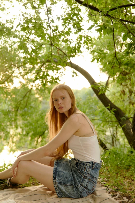 a woman sitting on a blanket in the woods, by Ivan Grohar, unsplash, renaissance, ginger hair with freckles, under the soft shadow of a tree, 1 6 years old, photo of green river