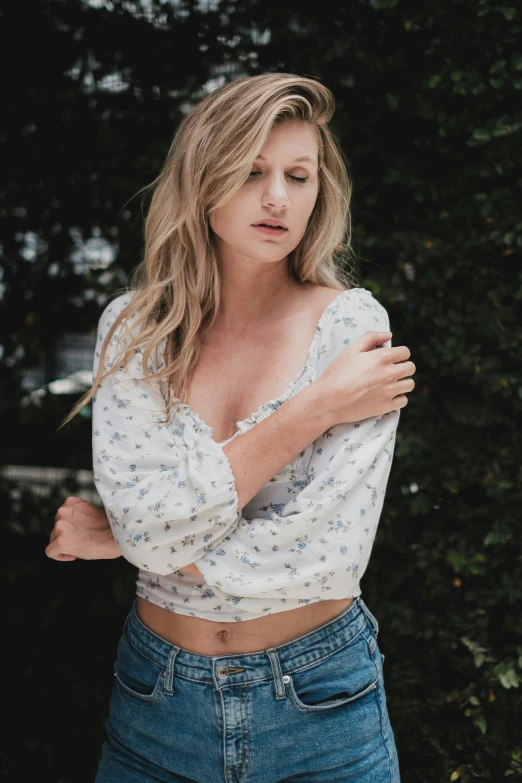 a woman standing in front of a tree, a colorized photo, by Chase Stone, trending on unsplash, renaissance, wearing a sexy cropped top, blonde beautiful young woman, white shirt and jeans, starry