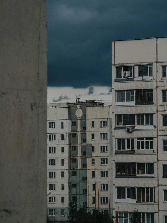 a couple of tall buildings sitting next to each other, inspired by Elsa Bleda, unsplash contest winner, brutalism, typical russian atmosphere, thunderstorm outside, low quality photo