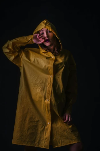 a woman in a yellow raincoat on a black background, unsplash, hyperrealism, wearing a fisher 🧥, clothing photography, full colour, low - angle shot