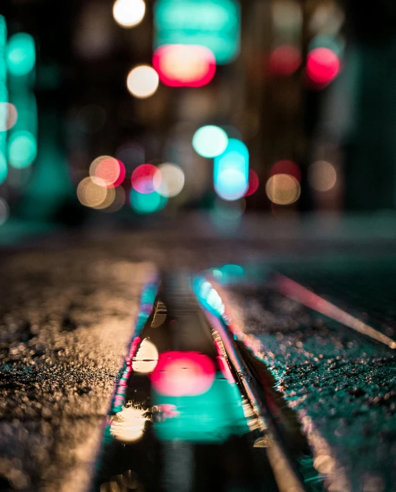 a city street filled with lots of traffic at night, an album cover, inspired by Elsa Bleda, pexels contest winner, bokeh. iridescent accents, glowing crystals on the ground, blue and green and red tones, wet road