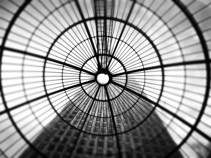 a black and white photo of the inside of a building, inspired by Alexander Rodchenko, unsplash, seen through a kaleidoscope, city rooftop, shot on iphone 1 3 pro max, rounded roof