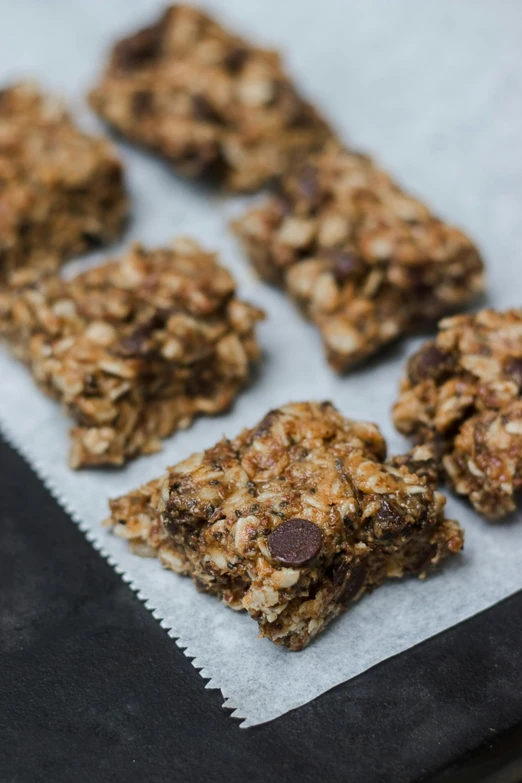 a tray of granola bars sitting on top of a table, a portrait, by Nina Hamnett, unsplash, square, chocolate. rugged, chiffon, on clear background