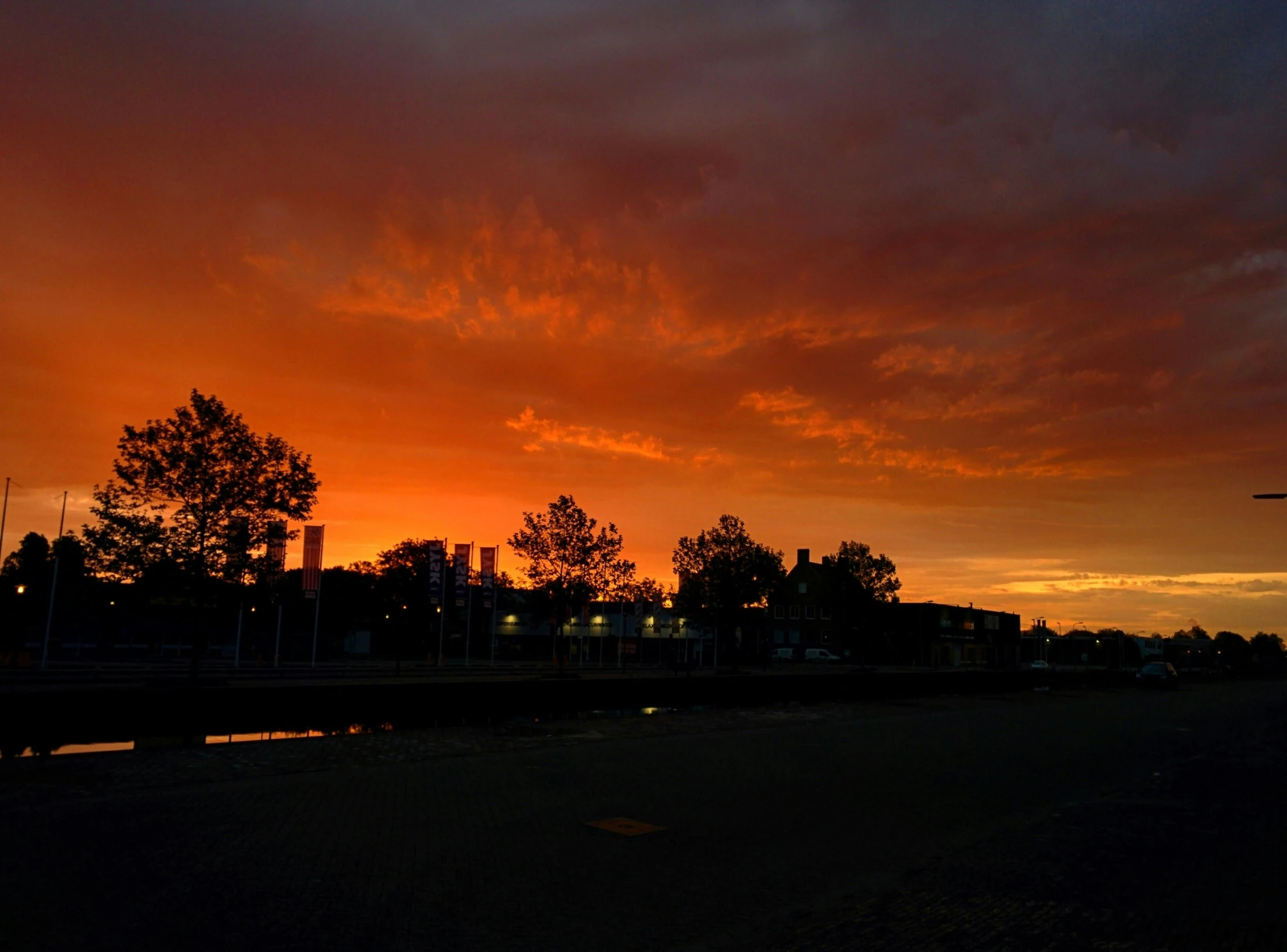 the sky is red and orange as the sun sets, by Jan Tengnagel, pexels contest winner, realism, caulfield, college, dark sky, 2022 photograph