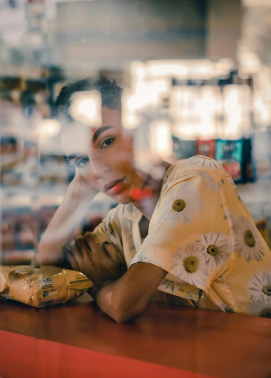 a woman laying on a counter in a store, a portrait, by Andrew Stevovich, trending on pexels, wearing yellow floral blouse, nostalgic melancholy, ashteroth, standing in a restaurant