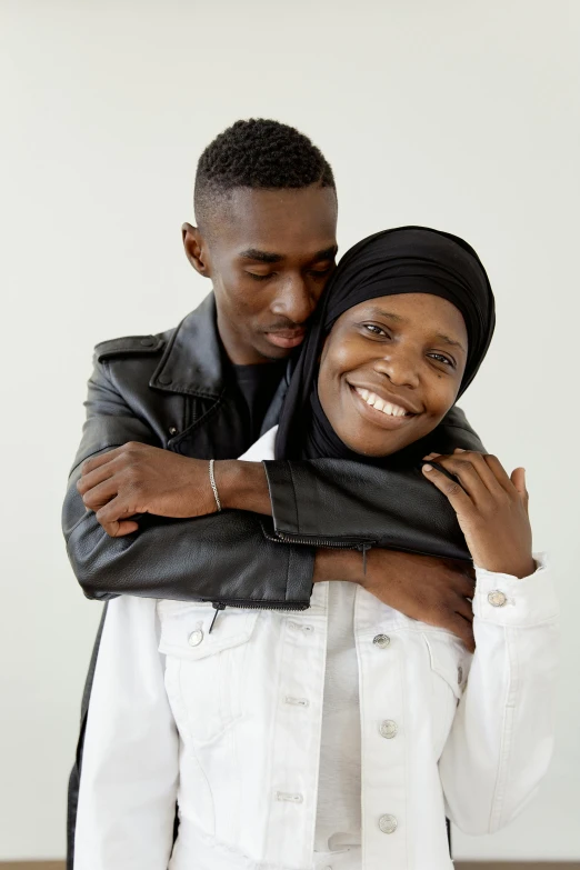 a man and a woman standing next to each other, by Matija Jama, hurufiyya, hugging each other, riyahd cassiem, genderless, official store photo