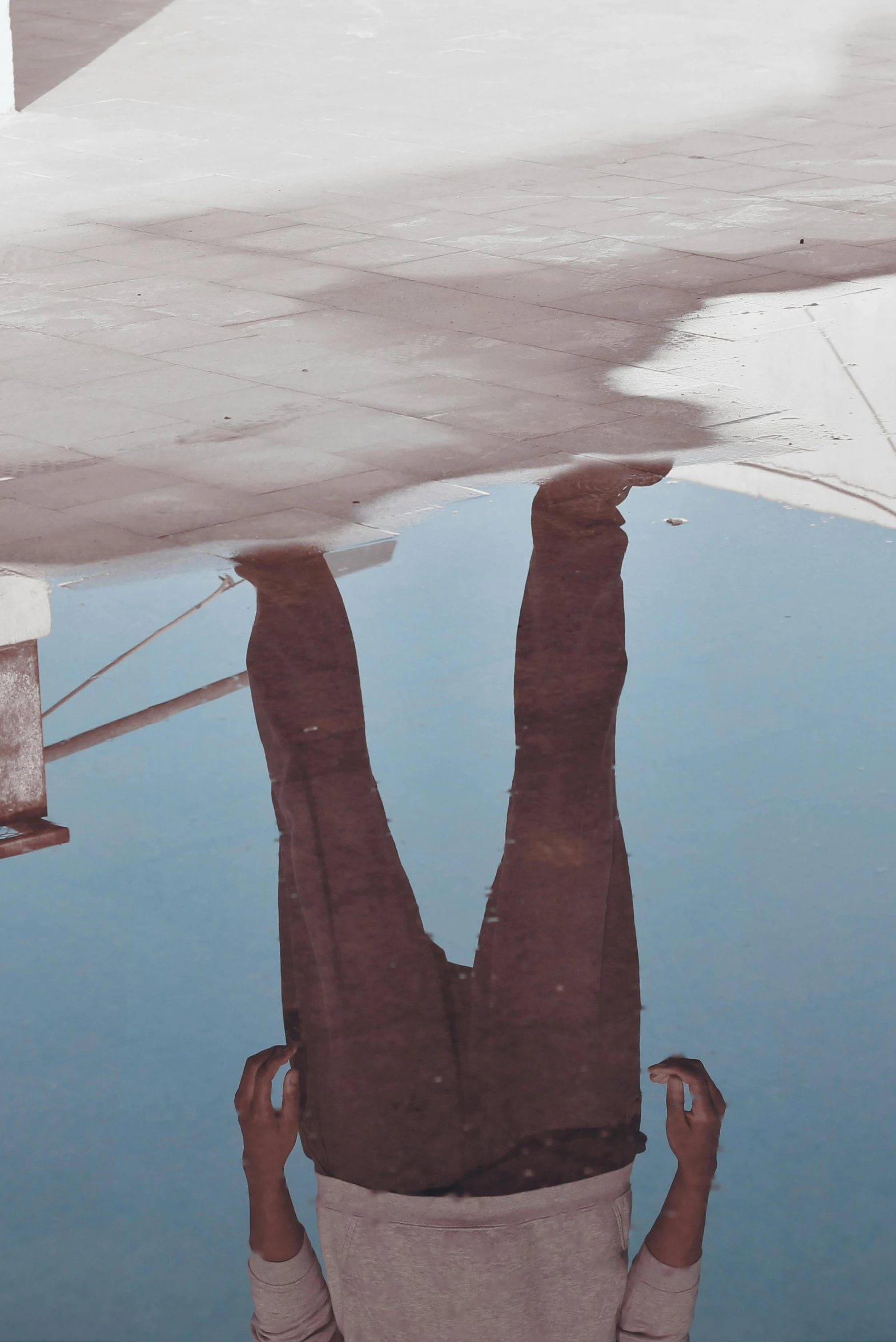 a reflection of a person upside down on the ground, inspired by Ren Hang, unsplash, conceptual art, standing on ship deck, drop shadow, inverted colors, taken in the late 2010s