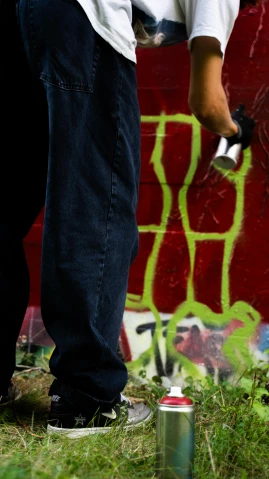 a man spraying graffiti on a wall with a spray can, pexels contest winner, green legs, black marker, daz, green and red