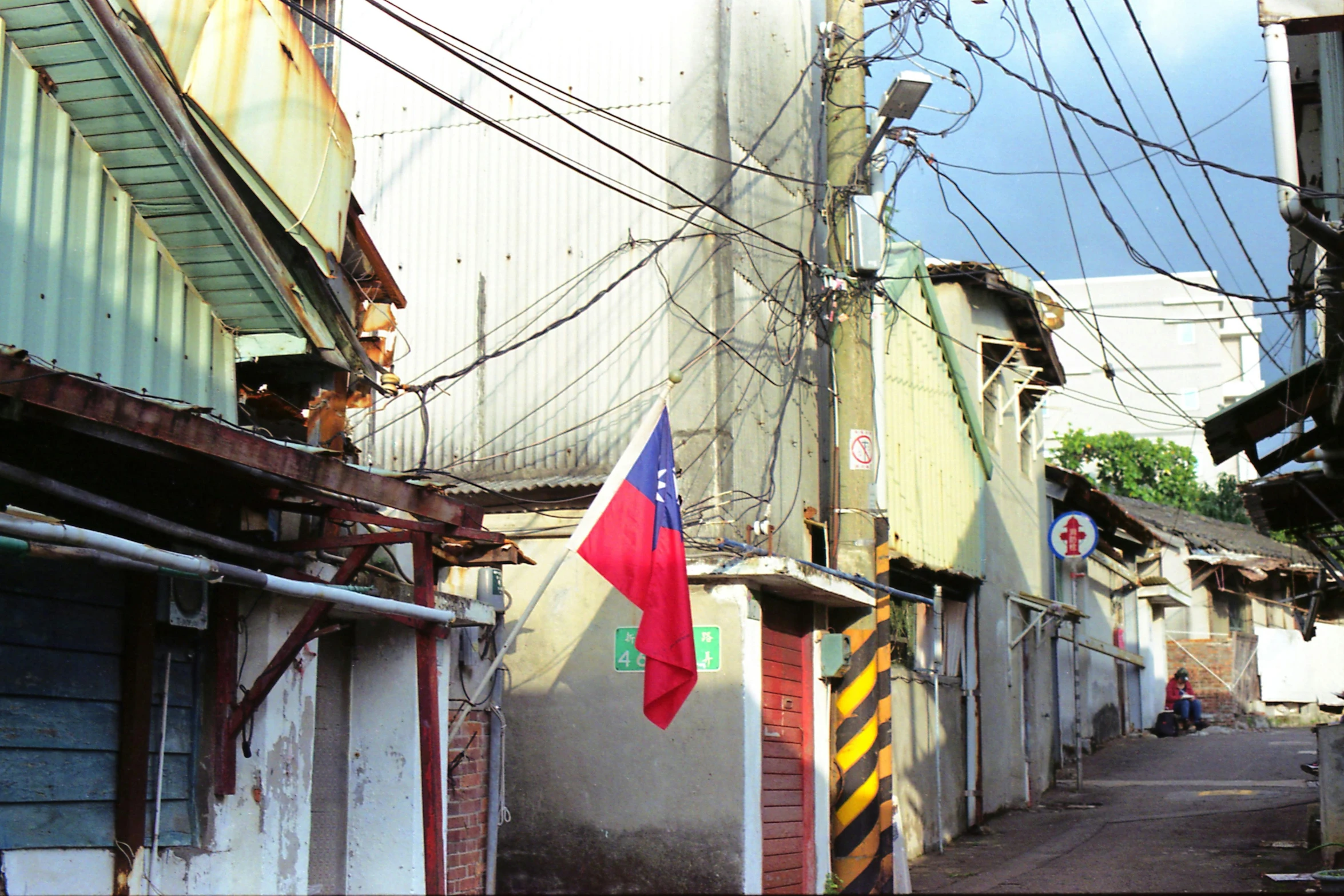 a flag hanging from the side of a building, an album cover, flickr, quito school, kowloon walled city, green alleys, sanctions in russia, 2 0 0 0's photo