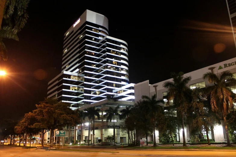 a very tall building sitting in the middle of a street, night on a summer miami beach, offices, listing image, exterior photo