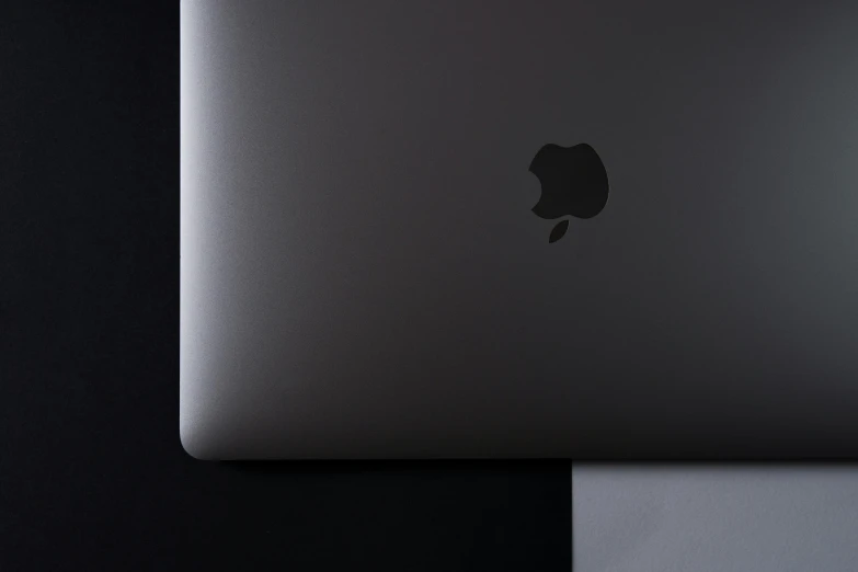 a laptop computer sitting on top of a table, by Carey Morris, pexels, computer art, apple logo, pitch black skin, solid grey, packshot