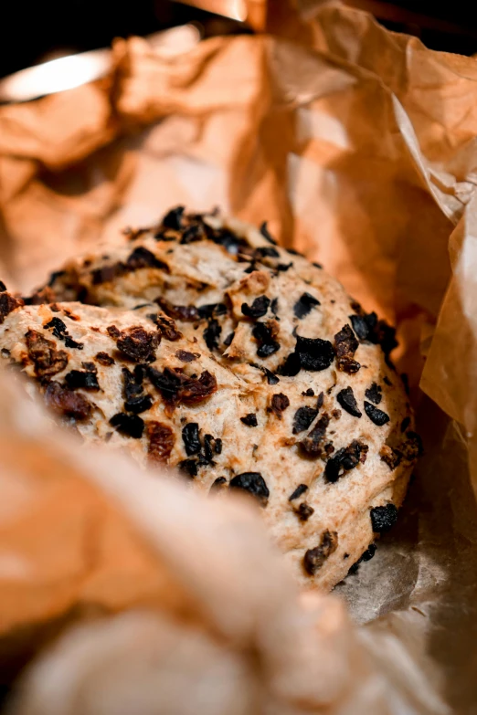 a piece of bread sitting on top of a piece of paper, by Jesper Knudsen, bakery, thumbnail, close-up photo, crushed