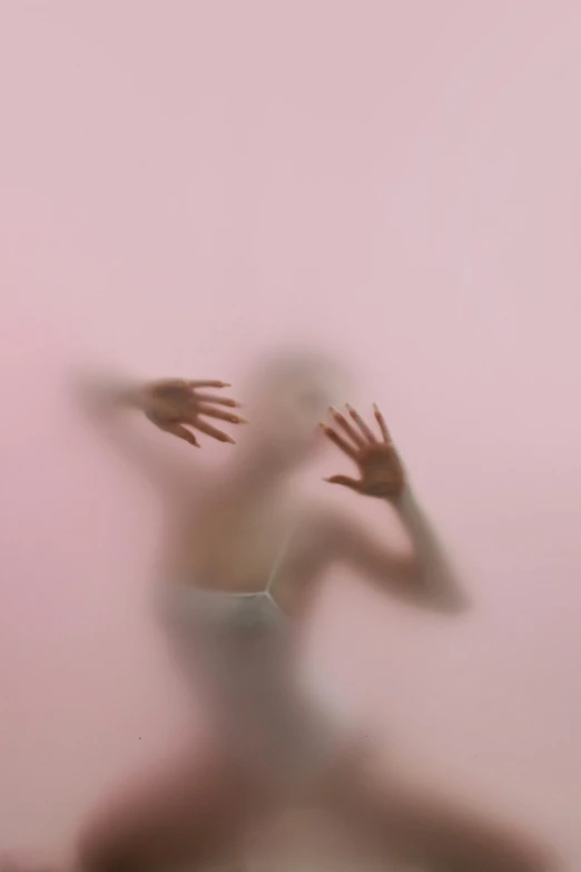 a blurry image of a person jumping in the air, inspired by Anna Füssli, pastel pink skin tone, hands shielding face, unnerving mist, pink background