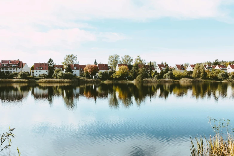 a body of water with houses in the background, by Sebastian Spreng, pexels contest winner, near pond, crisp smooth clean lines, swanland, ede laszlo
