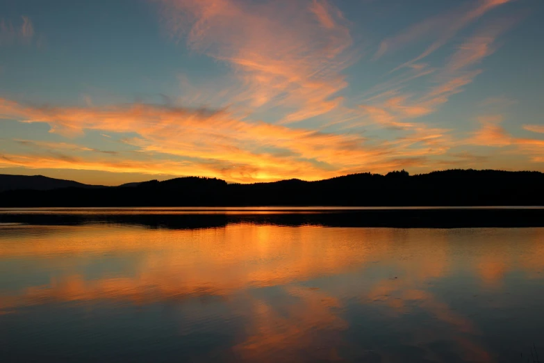 a large body of water with a sunset in the background, a picture, big bear lake california, fan favorite, uploaded, multicoloured