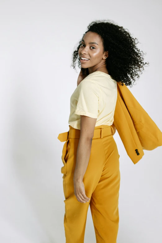 a woman in a yellow shirt and yellow pants, trending on unsplash, white bg, thumbnail, cropped shirt with jacket, photographed for reuters