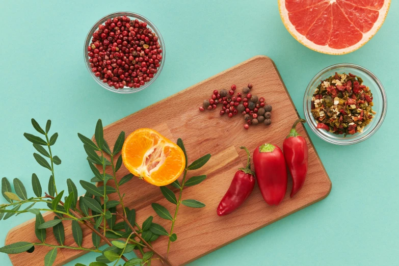 a cutting board with various fruits and vegetables on it, by Julia Pishtar, coral red, spices, teal orange, product shot