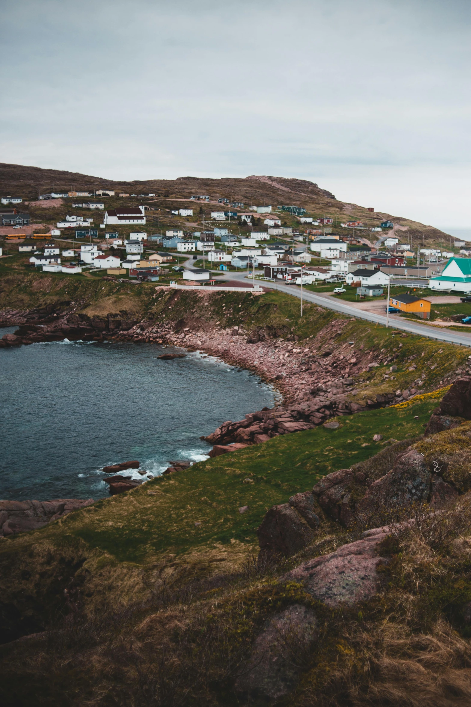 a small town sitting on top of a hill next to a body of water, by Kyle Lambert, les nabis, rocky coast, hziulquoigmnzhah, pov photo