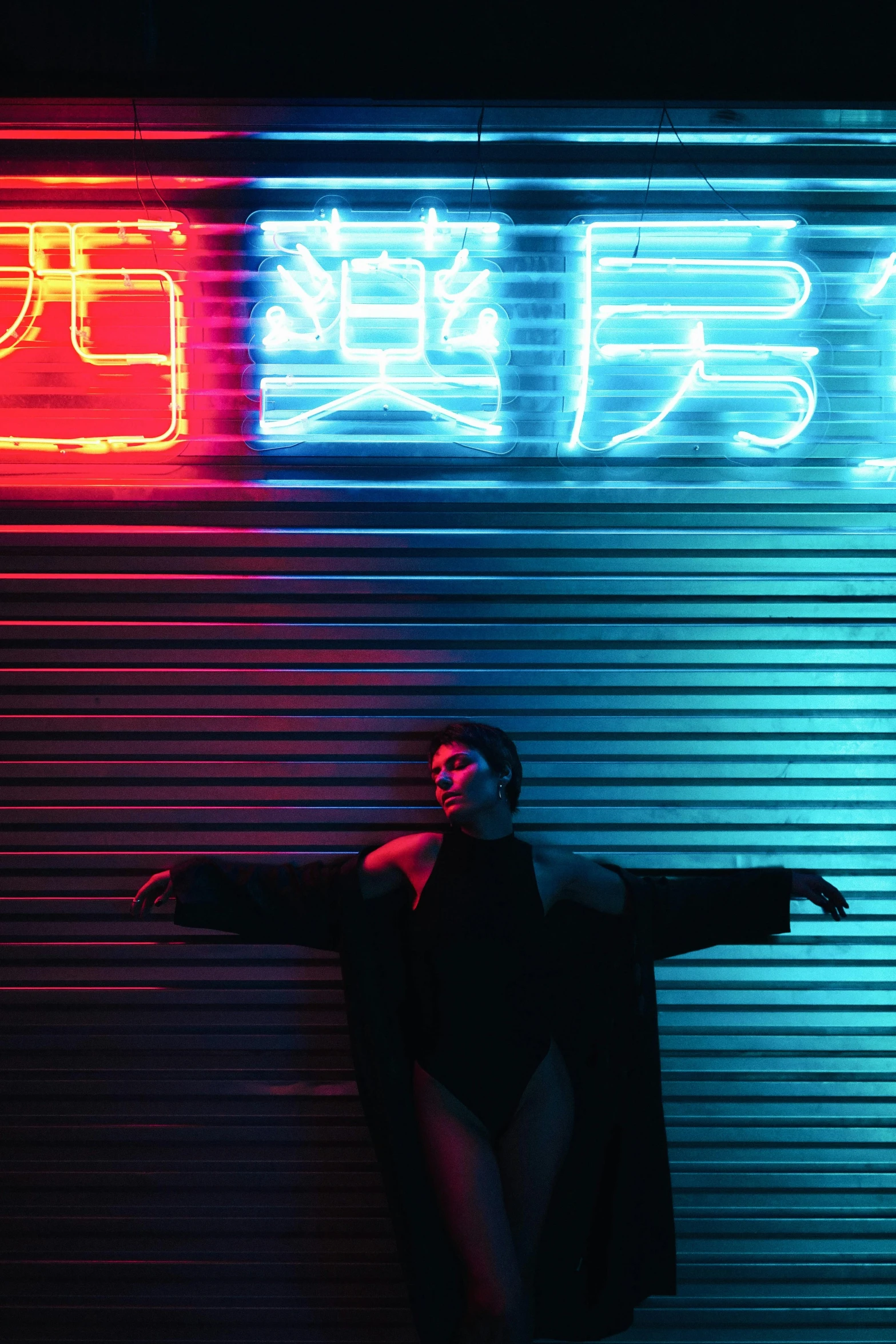 a man standing in front of a neon sign, inspired by Ren Hang, unsplash, chinese woman, arms stretched out, yung lean, red and blue black light