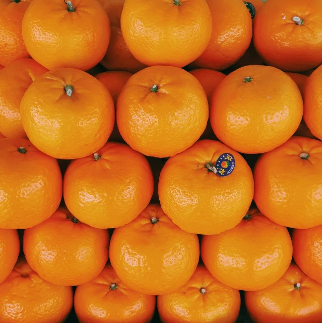 a pile of oranges sitting on top of each other, by Carey Morris, pexels contest winner, pareidolia, geometrically correct, 🦩🪐🐞👩🏻🦳, a still of a happy