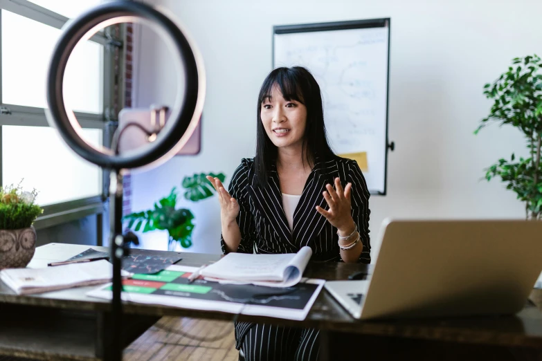 a woman sitting at a desk in front of a laptop computer, inspired by helen huang, pexels contest winner, ring light, giving an interview, avatar image, instagram picture