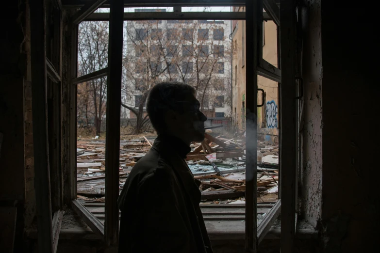 a man standing in front of an open window, by Adam Marczyński, pexels contest winner, graffiti, massive destruction, typical russian atmosphere, abandoned hospital, profile picture 1024px