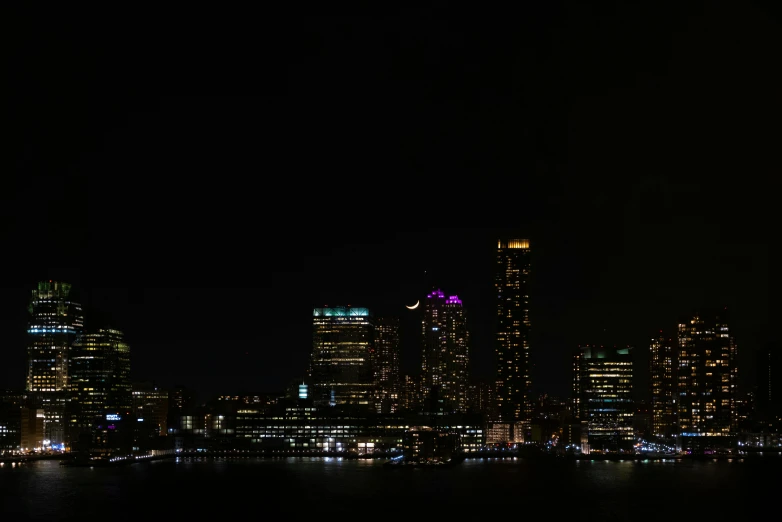 the city skyline is lit up at night, by Joseph Severn, pexels contest winner, minimalism, with a black background, panoramic, new jersey, three fourths view